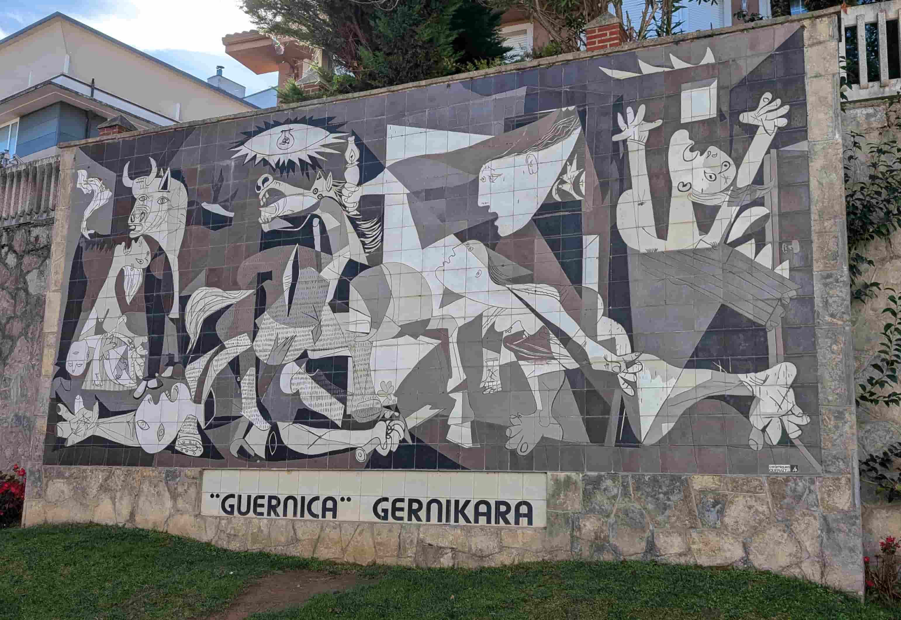 A reproduction of Picasso's "Guernica" as a mural in Gernika-Lumo. The words "'Guernica' gernikara" ("bring 'Guernica' to Gernika") are inscribed below it.